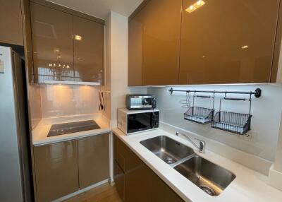 Modern kitchen with cabinets, stove, microwave, and double sink