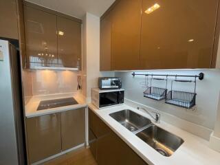 Modern kitchen with cabinets, stove, microwave, and double sink