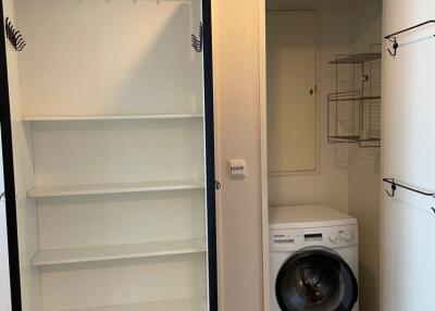 Laundry room with washer and open shelving