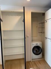 Laundry room with washer and open shelving