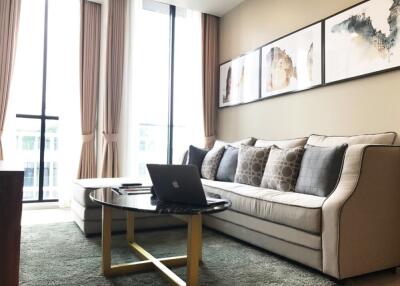 Modern living room with sofa, coffee table, and large windows