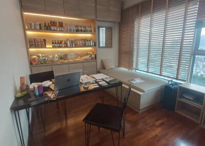 Home office with built-in shelves, wooden flooring, desk, and large window