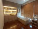 Well-lit room with wooden flooring and a built-in storage bench