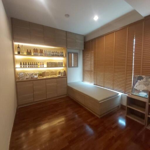 Well-lit room with wooden flooring and a built-in storage bench