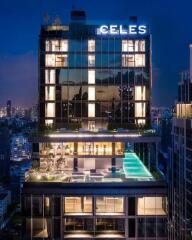 Modern high-rise building with illuminated windows and rooftop pool