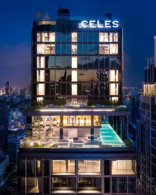 Modern high-rise building with illuminated windows and rooftop pool