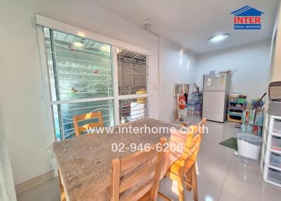 Small kitchen area with dining table and fridge