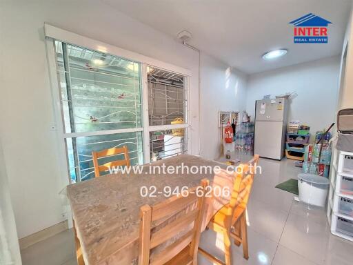 Small kitchen area with dining table and fridge