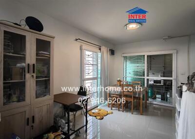 Dining area with wooden table and chairs, glass cabinet, and window