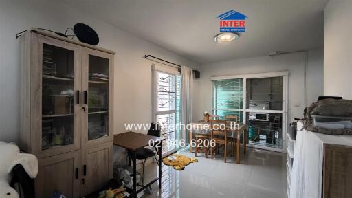 Dining area with wooden table and chairs, glass cabinet, and window