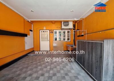 Room with orange walls and window, featuring air conditioner and tiled floor