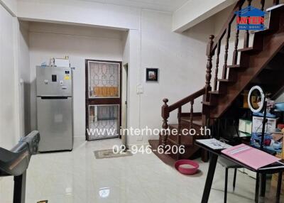 Main living area with stairway, refrigerator, and desk