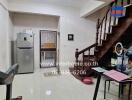 Main living area with stairway, refrigerator, and desk