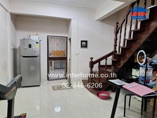 Main living area with stairway, refrigerator, and desk