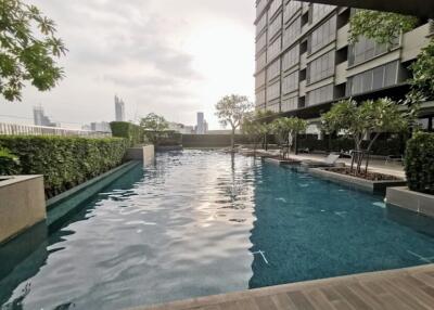 Modern outdoor pool area with surrounding greenery and lounge chairs