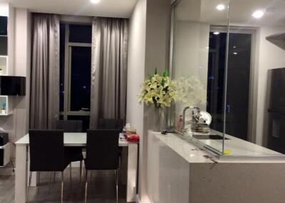 Modern kitchen and dining area with glass partition and flowers