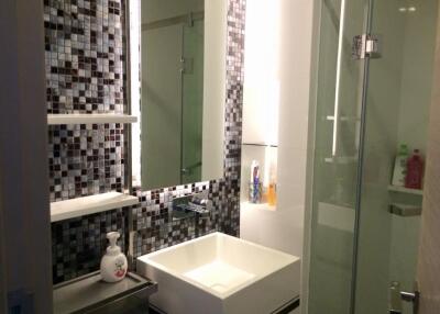 Modern bathroom with mosaic tiles and glass shower