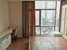 Bedroom with a large window, city views, a desk, and a chair