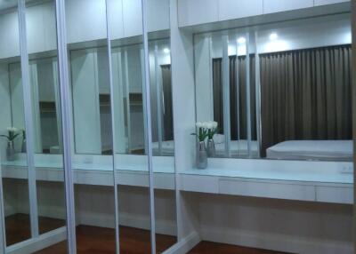 Modern bedroom with mirrored closet and wooden floor