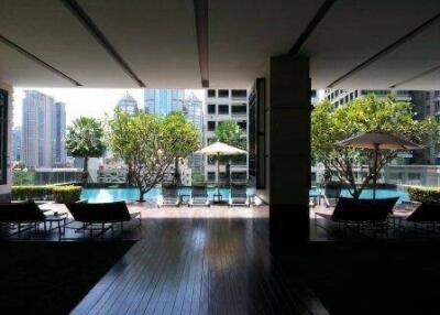 Outdoor pool area with lounge chairs and umbrellas