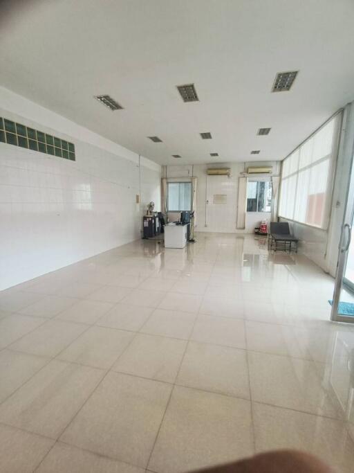 Spacious commercial area with tiled flooring and large windows