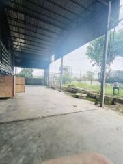 Covered outdoor industrial area with view of green landscape