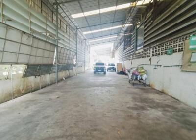 Spacious covered garage area with a car and storage