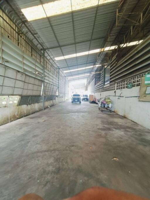 Spacious covered garage area with a car and storage