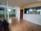 Spacious living area with wooden flooring and large windows