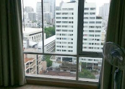 Bedroom with large window and city view