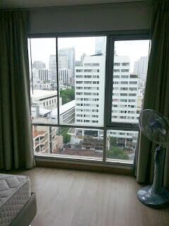 Bedroom with large window and city view