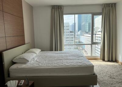 Modern bedroom with large window and city view