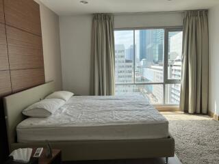 Modern bedroom with large window and city view