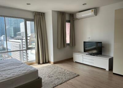 Modern bedroom with large windows and city view