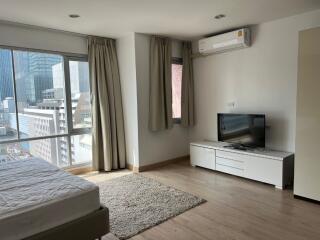 Modern bedroom with large windows and city view