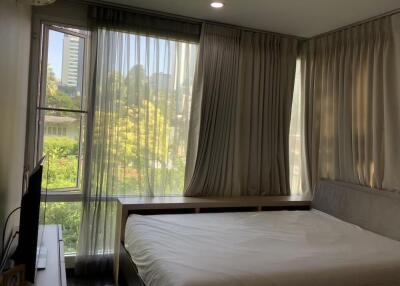 Well-lit bedroom with large windows and modern decor