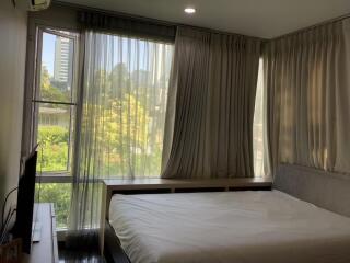 Well-lit bedroom with large windows and modern decor