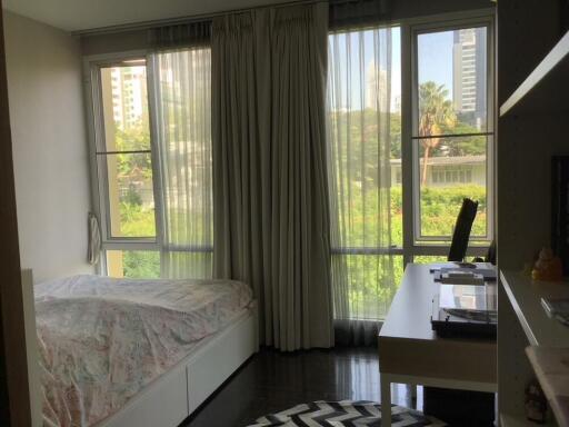 Bright bedroom with large windows and a desk