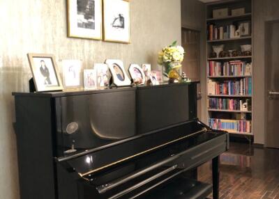 Living room with a piano and bookshelf