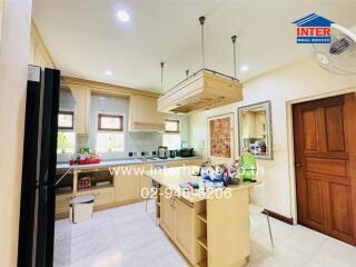 Modern kitchen with wooden cabinets, central island, and appliances