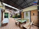 Outdoor patio with wooden flooring, seating area, and plants