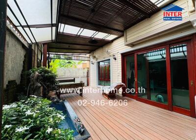 Covered patio area with wooden flooring and garden