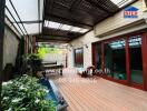 Covered patio area with wooden flooring and garden