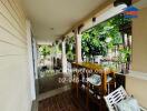 Covered balcony area with seating and view of garden