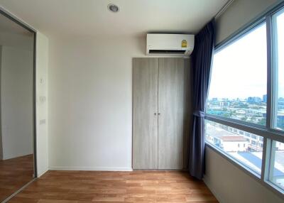 Bright bedroom with wooden floor and large window