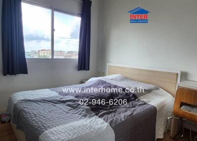 Bedroom with a bed, window, and wooden desk chair