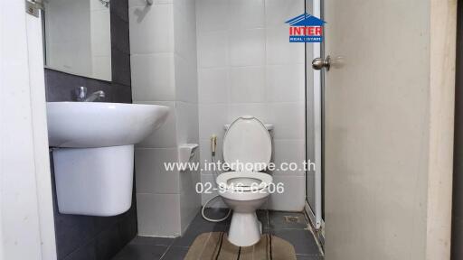 Small bathroom with a toilet, sink, and tiled floor