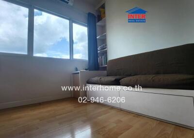 Living room with large window and brown sofa