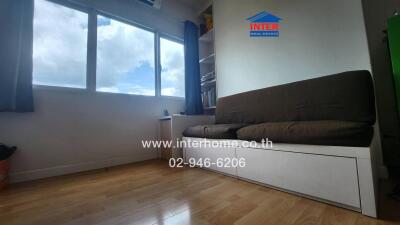 Living room with large window and brown sofa