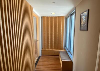 Bright, modern hallway with wooden paneling and seating area